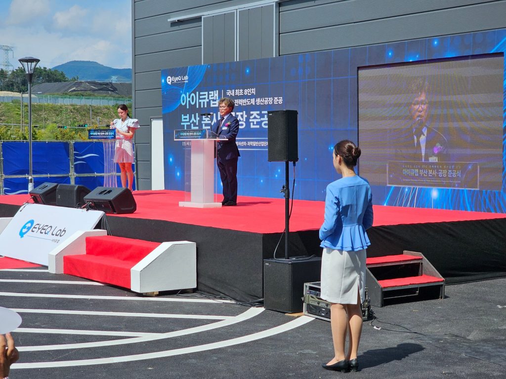 배경 현수막과 LED 화면을 갖춘 준공식 무대 발언대