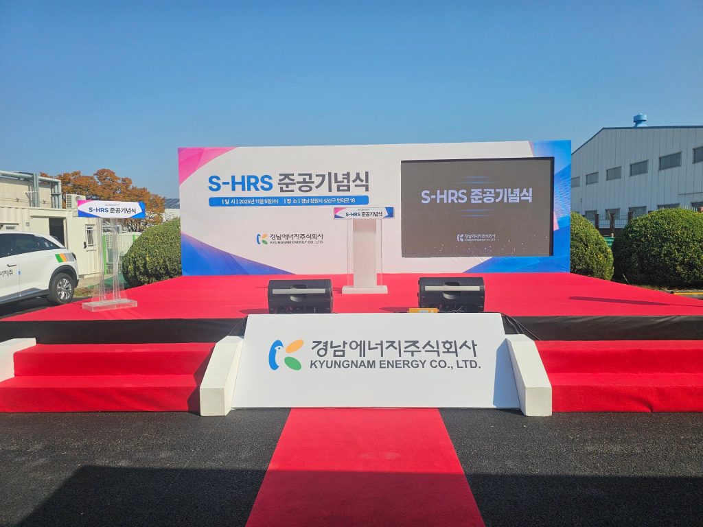 행사명과 회사 정보를 담은 준공기념식 무대 배경과 발언대